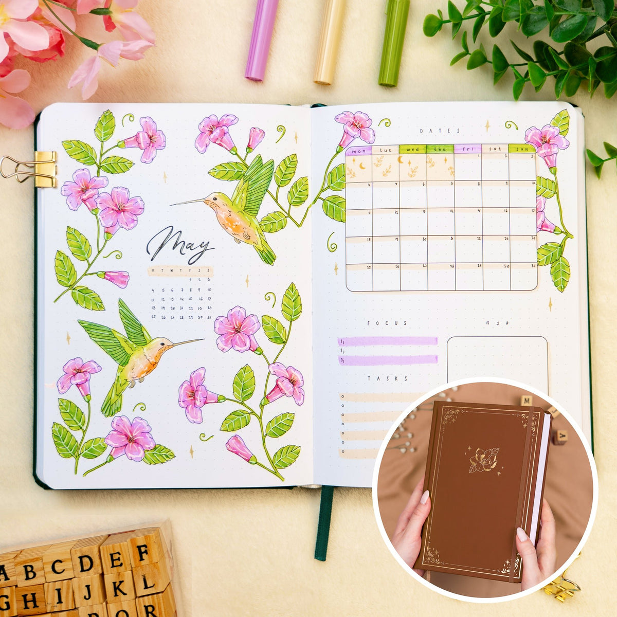 Opened premade bullet style journal with flowers and hummingbirds