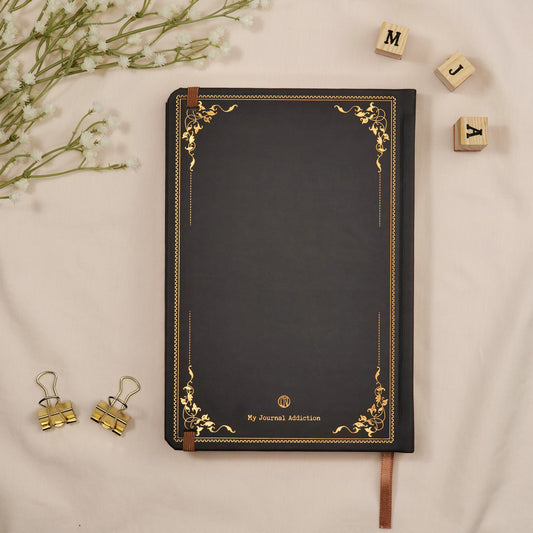 Vegan leather back cover of the deep gray Asphalt dotted premade bullet style travel journal with embossed gold copper logo detail.