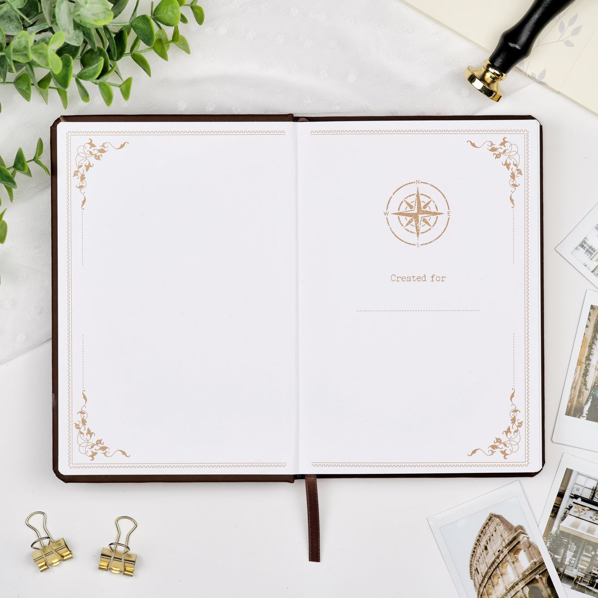 First pages of an opened premade travel journal, featuring a compass artwork and a designated space for writing your name.