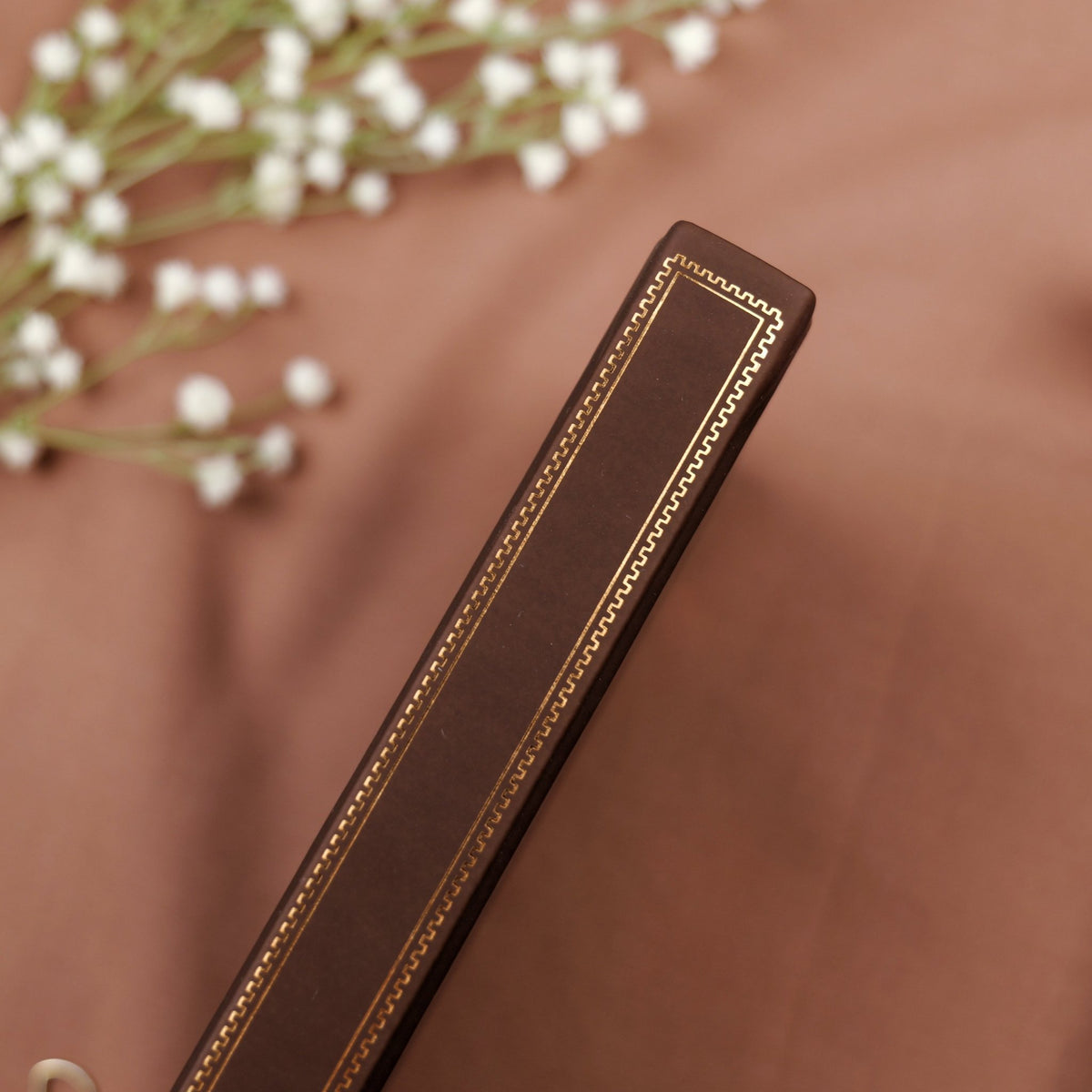 Showing the embossed gold copper detail on the spine of the premade traveling notebook.