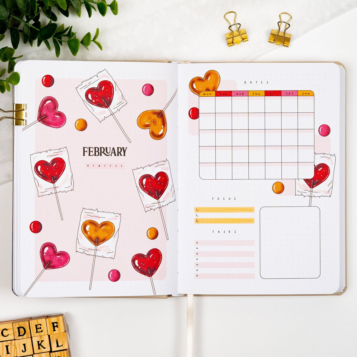 February monthly cover page of a premade journal, with heart lollipops artwork, calendar, and dedicated sections for goals and tasks.