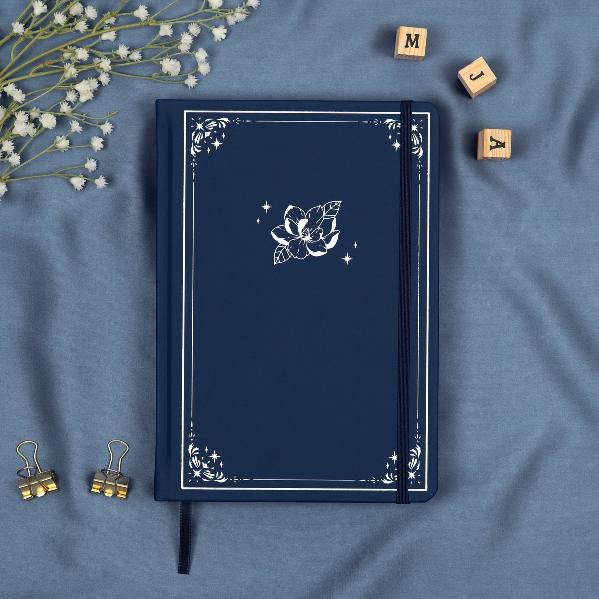 Blue Midnight premade dotted bullet style journal made of Italian vegan leather with an embossed silver magnolia design.