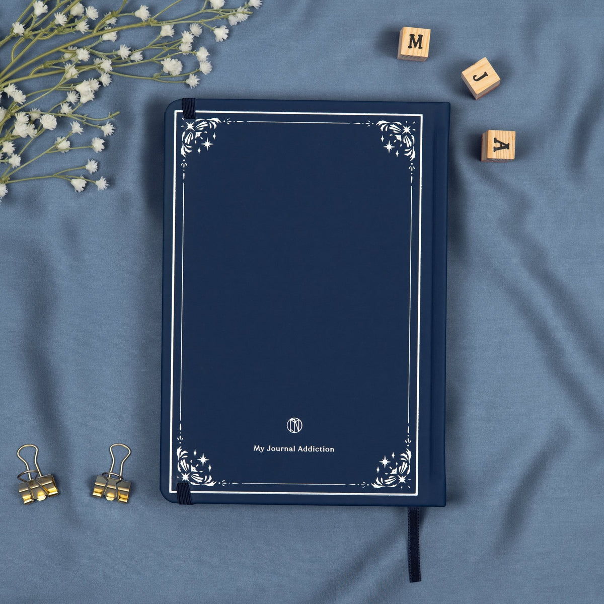 Vegan leather back cover of the blue midnight premade bullet style journal with embossed silver logo detail.