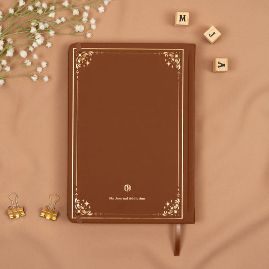 Vegan leather back cover of the brown cinnamon premade bullet style journal with embossed gold logo detail.