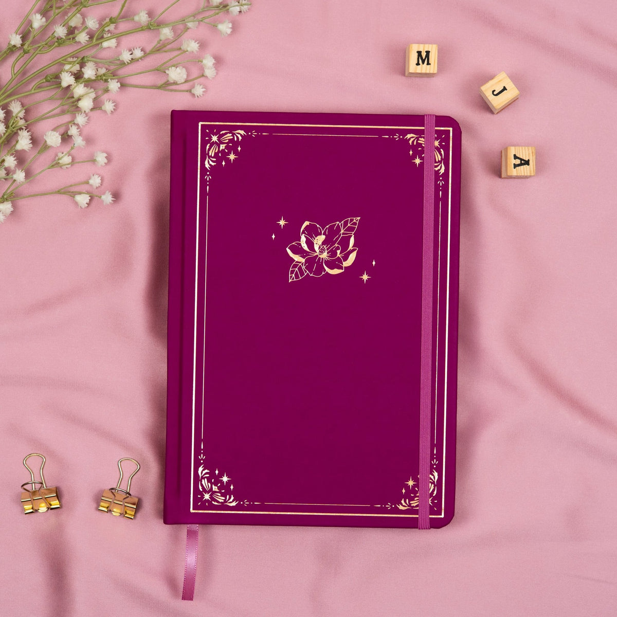 Plum premade dotted bullet style journal made of Italian vegan leather with an embossed gold magnolia design.