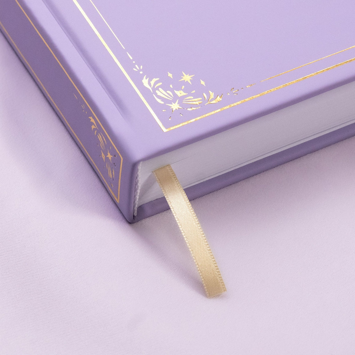 Showing the embossed gold detail and satin beige bookmark of the light purple Lavender pre-colored premade bullet style journal.