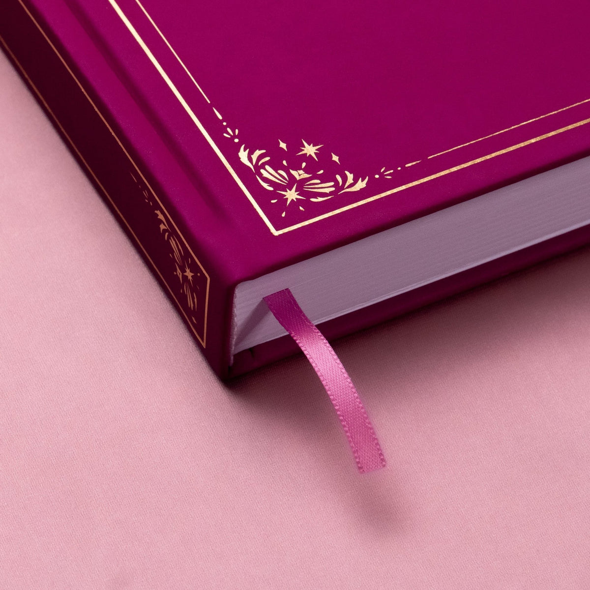 Showing the embossed gold detail and satin pink bookmark of the Plum premade bullet style journal.