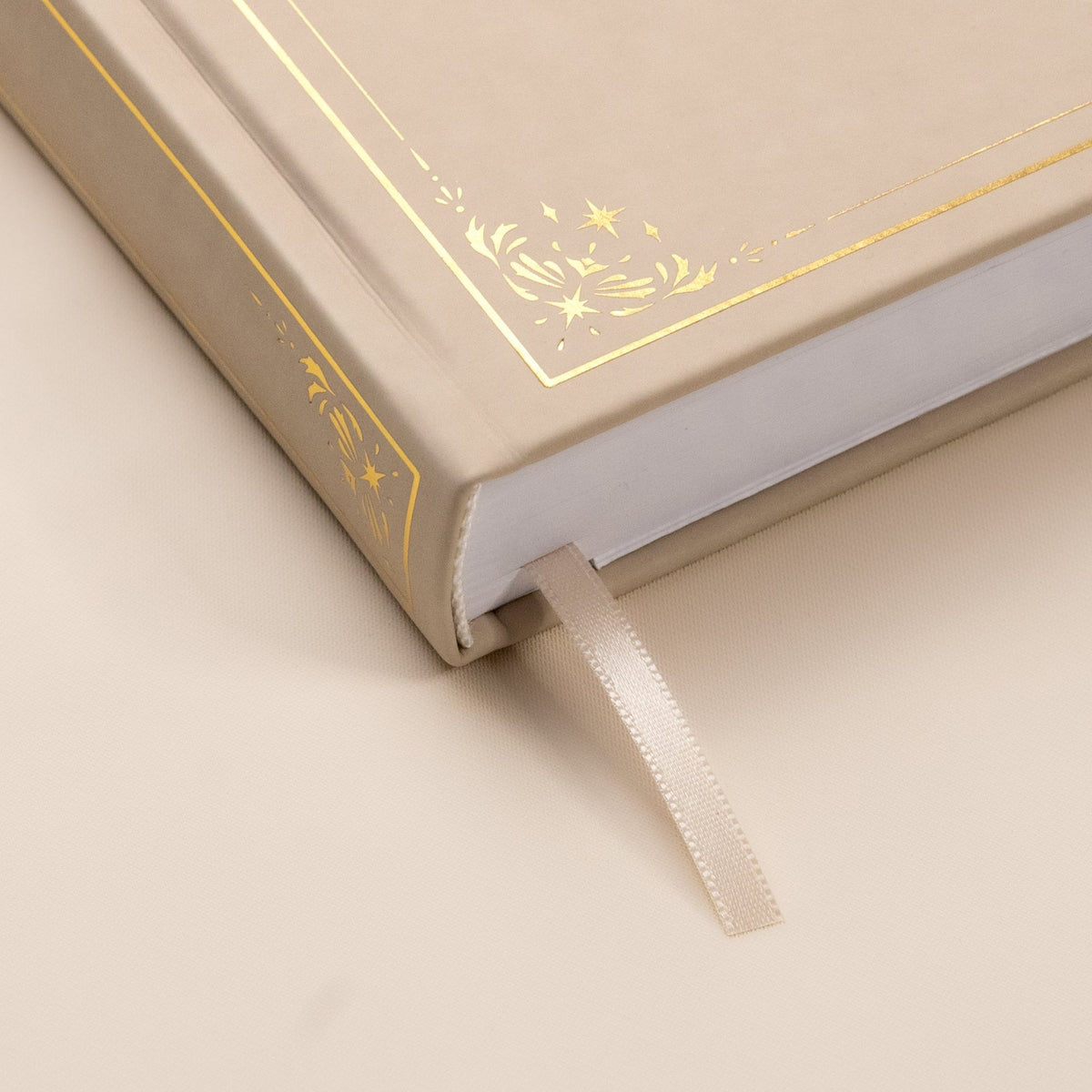 Showing the embossed gold detail and satin beige bookmark of the Oat premade bullet style journal.
