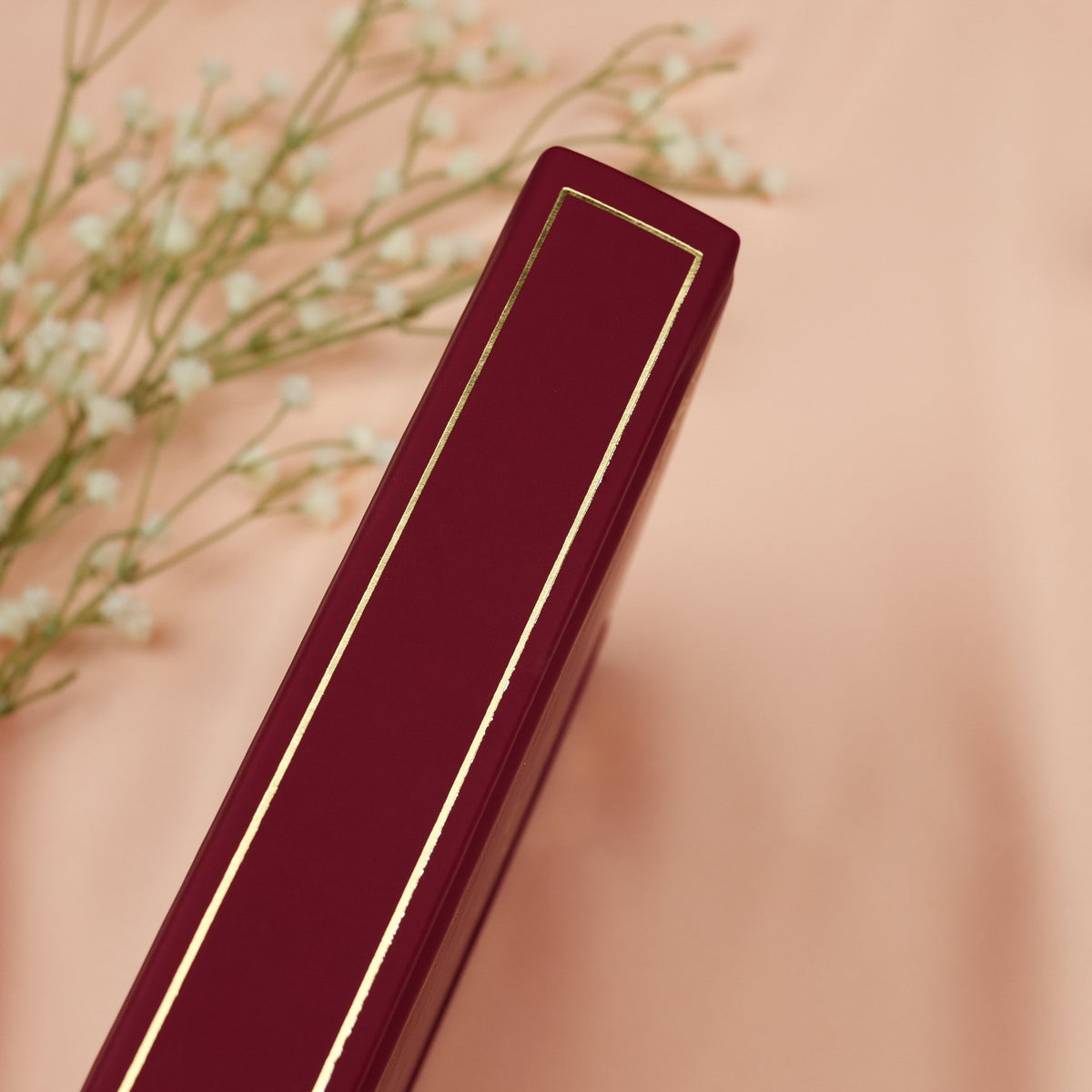 Showing the embossed gold detail on the spine of the red Forbidden Fruit premade bullet style journal.