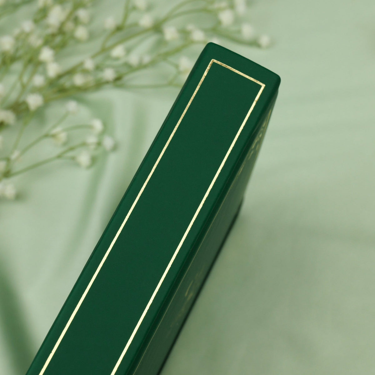 Showing the embossed gold detail on the spine of the deep green Poison Ivy premade bullet style journal.