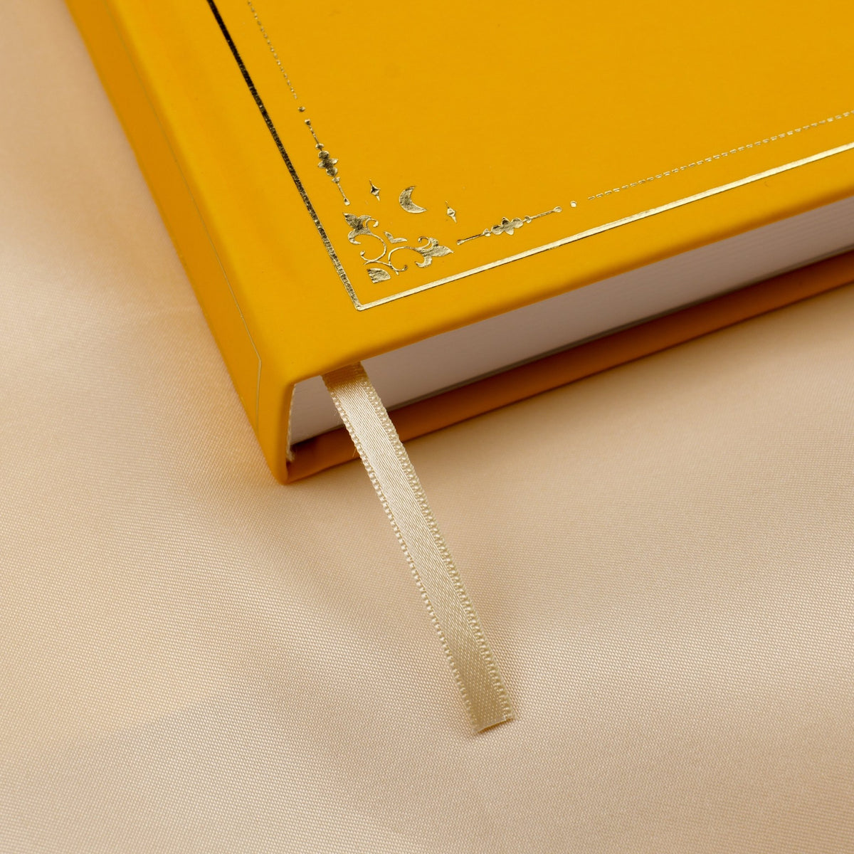Showing the embossed gold detail and satin beige bookmark of the yellow Honey Spice premade bullet style journal.