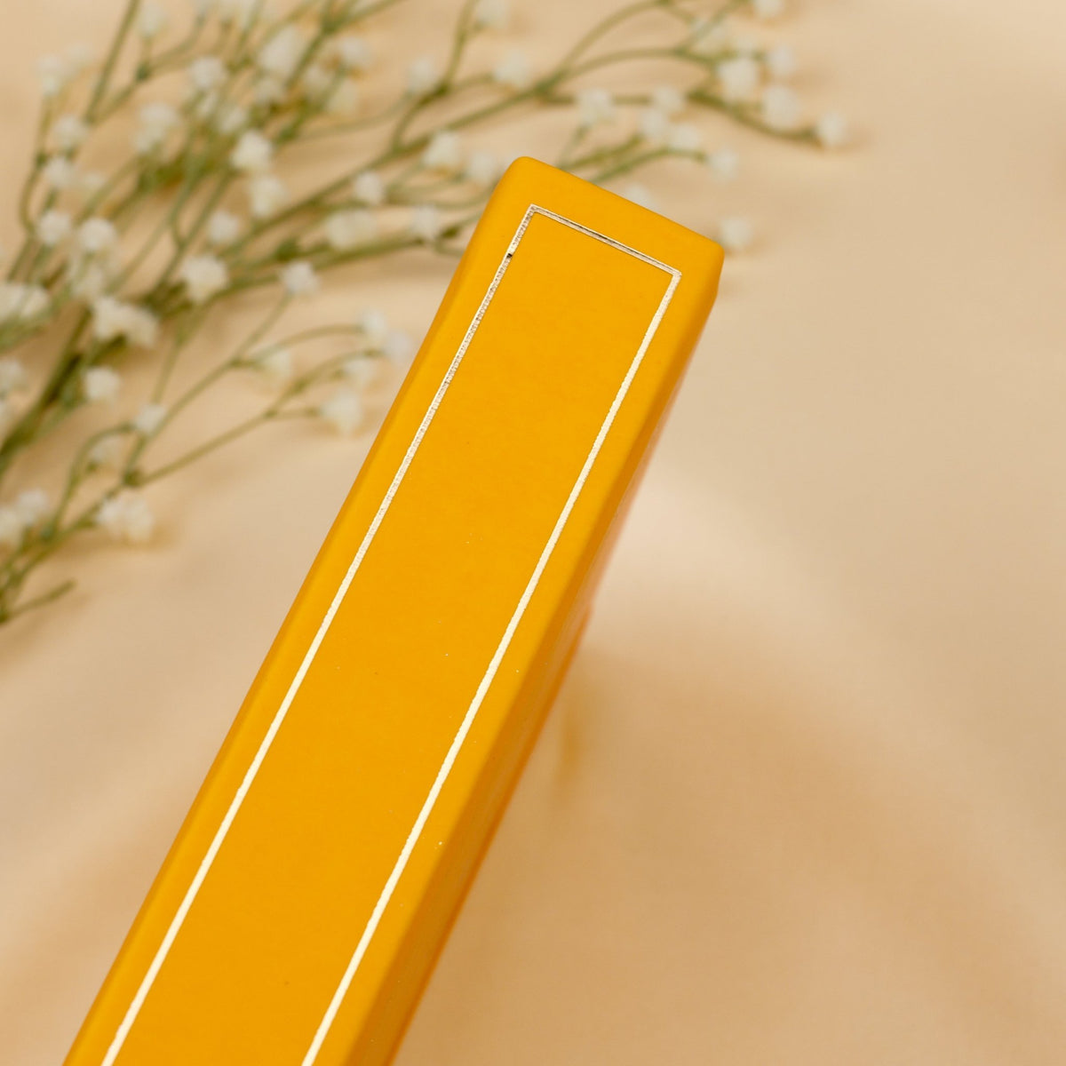 Showing the embossed gold detail on the spine of the yellow Honey Spice premade bullet style journal.