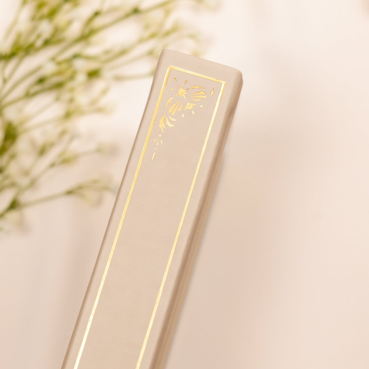 Showing the embossed gold detail on the spine of the Oat beige premade bullet style journal.