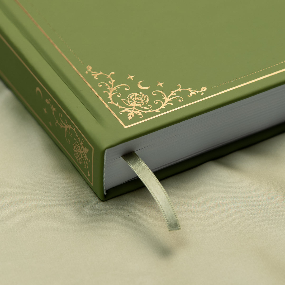 Embossed gold detail and satin pink bookmark of a premade bullet style journal.
