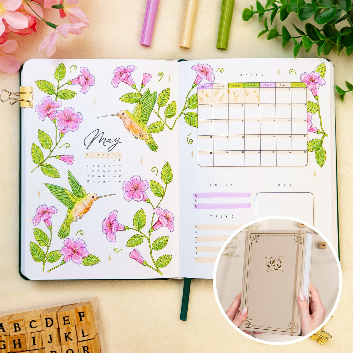 Opened premade bullet style journal with flowers and hummingbirds