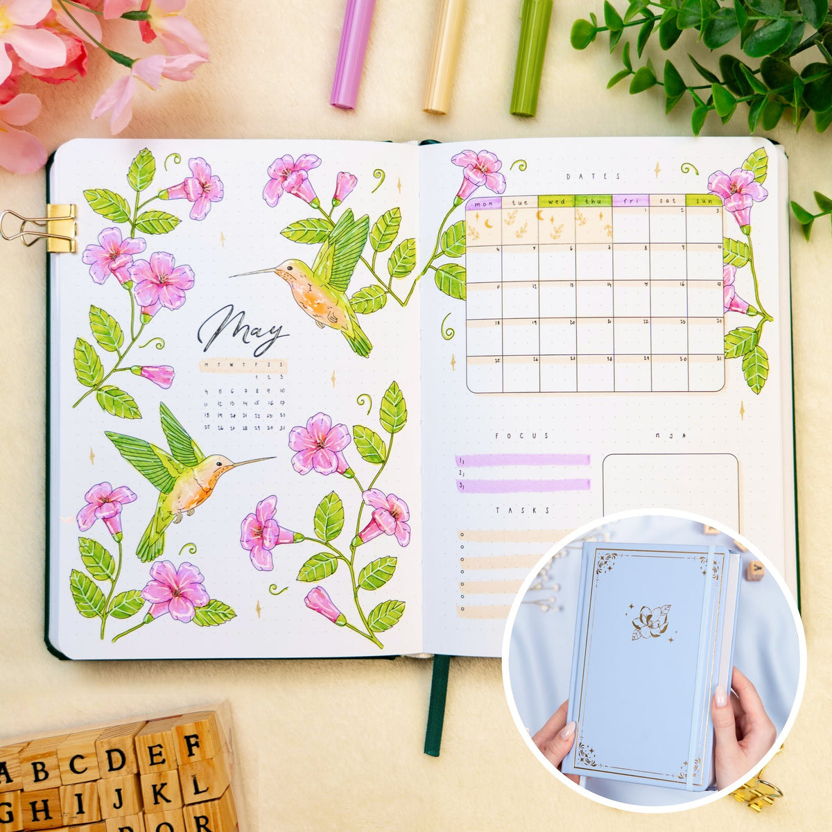 Opened premade bullet style journal with flowers and hummingbirds