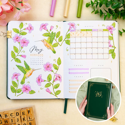 Opened premade bullet style journal with flowers and hummingbirds