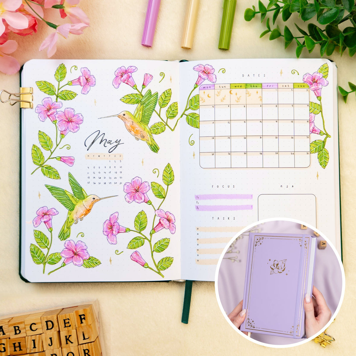 Opened premade bullet style journal with flowers and hummingbirds