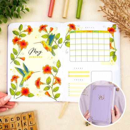Opened premade bullet style journal with flowers and hummingbirds