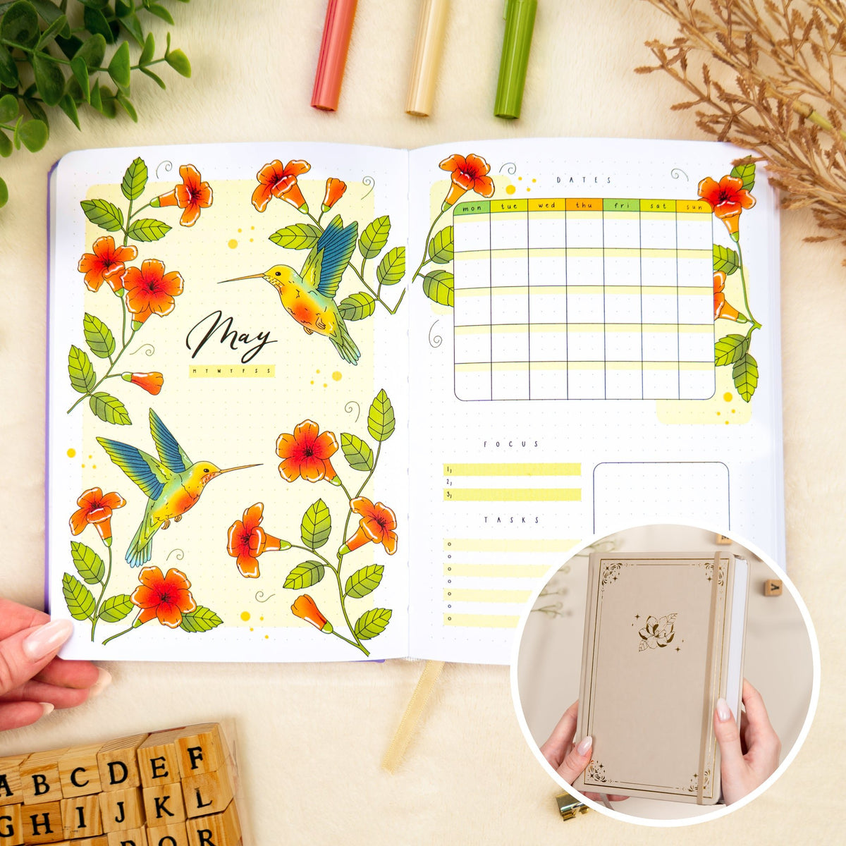 Opened premade bullet style journal with flowers and hummingbirds