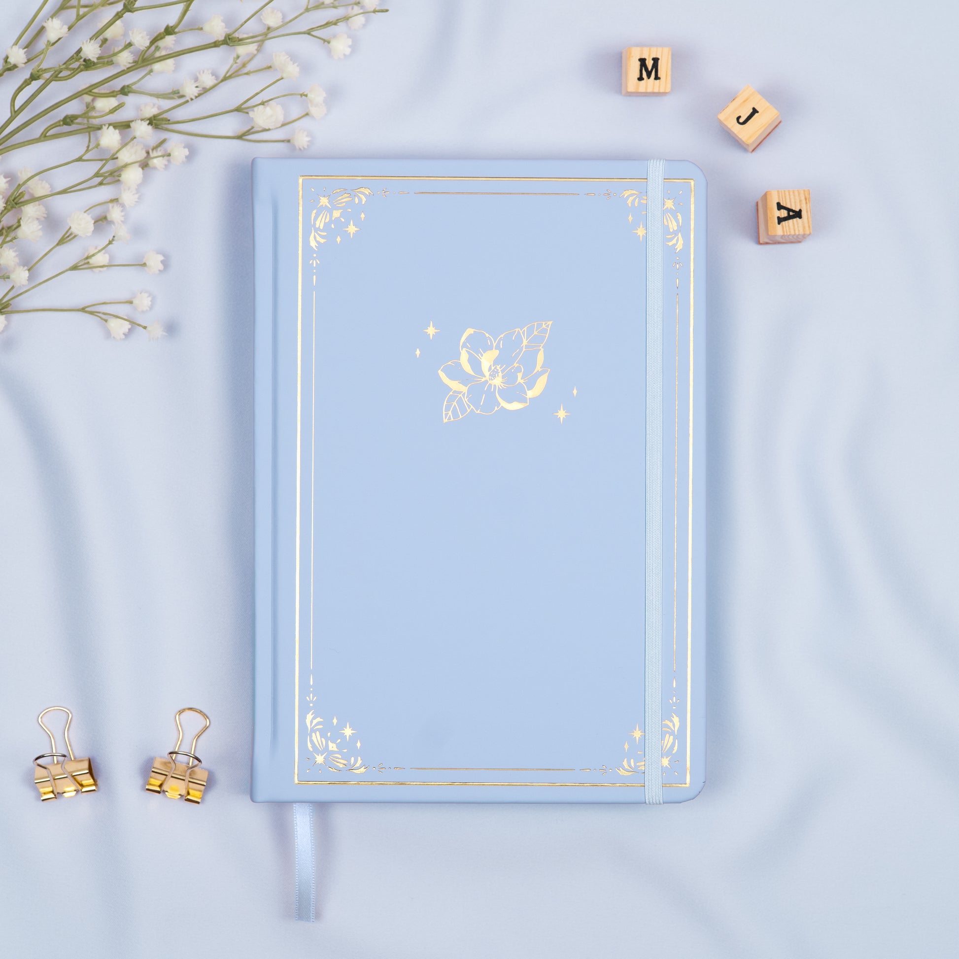 Cloud Light Blue premade dotted bullet style journal made of Italian vegan leather with an embossed gold magnolia design.