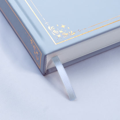 Showing the embossed gold detail and satin light blue bookmark of the Cloud light blue premade bullet style journal.