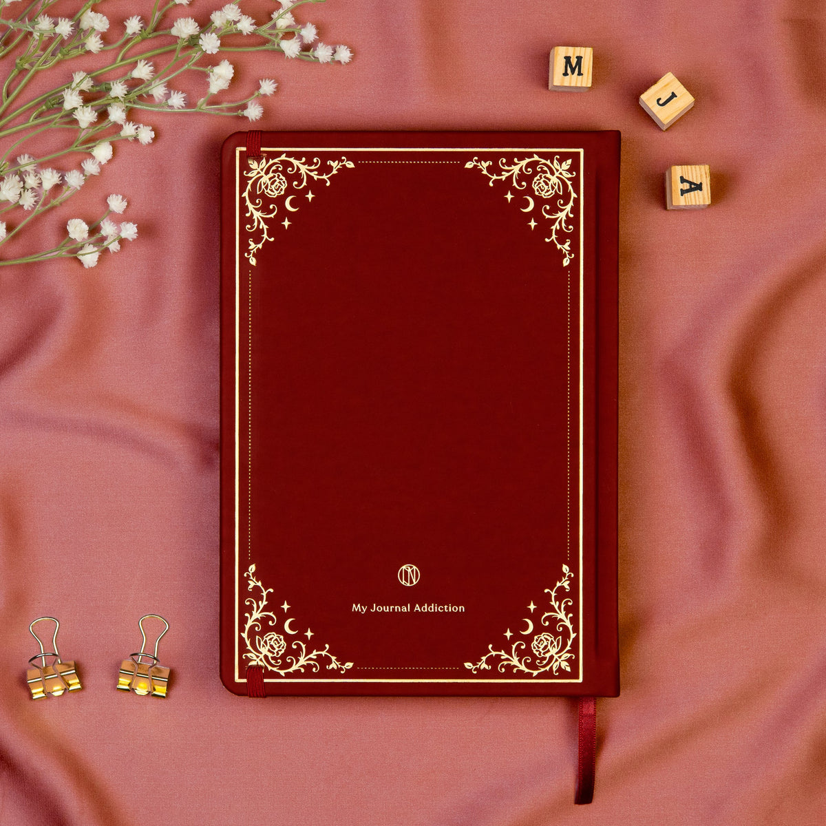 Vegan leather back cover of the Burgundy premade bullet style journal with embossed gold logo detail. 