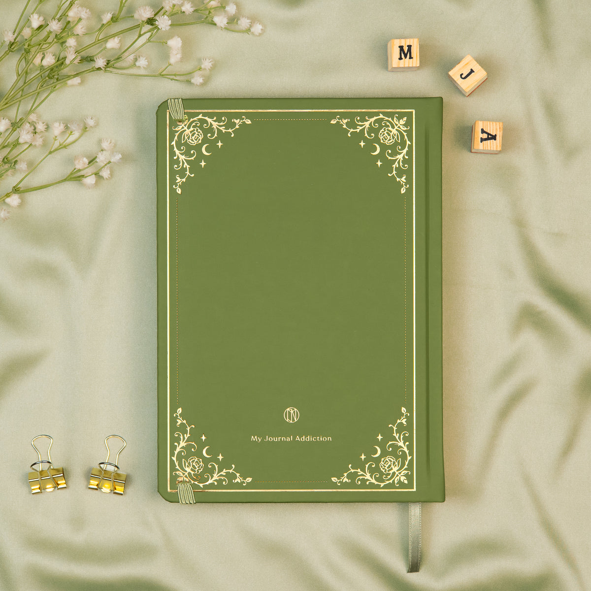 Vegan leather back cover of the Sage premade bullet style journal with embossed gold logo detail. 