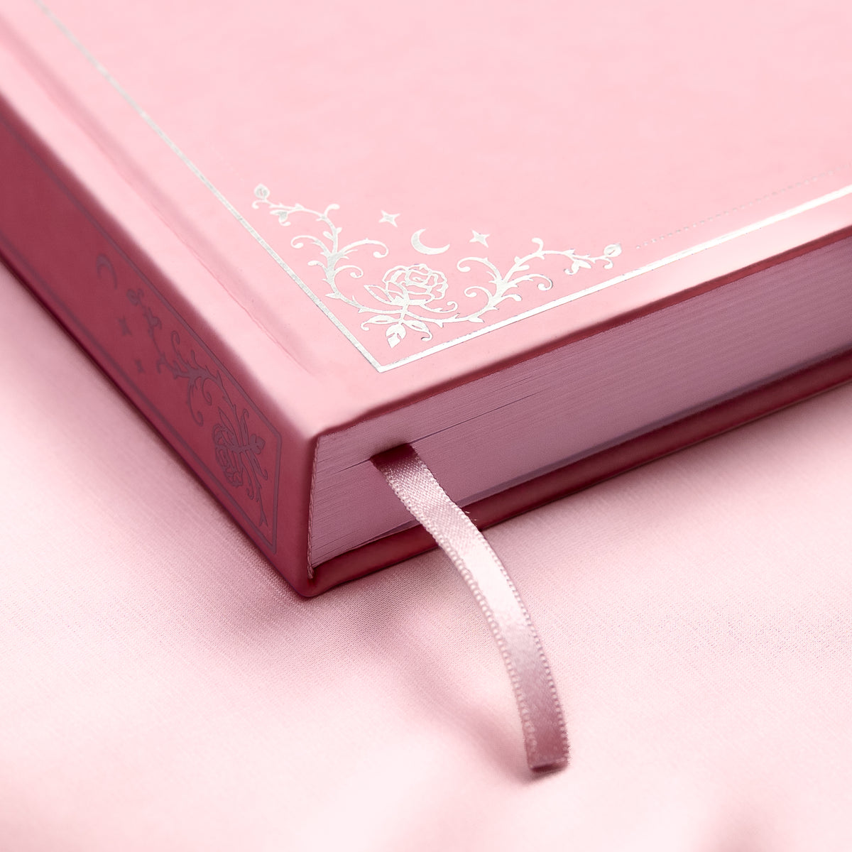 Embossed gold detail and satin pink bookmark of a premade bullet style journal.