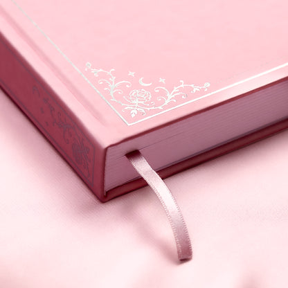 Embossed gold detail and satin pink bookmark of a premade bullet style journal.