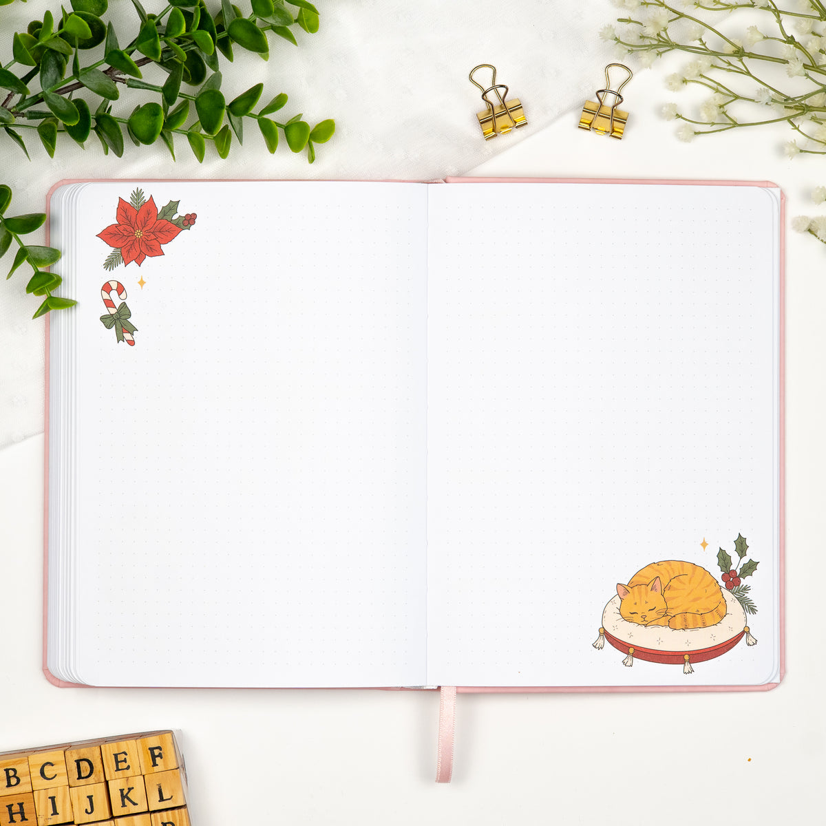 Monthly empty pages of a colored predesigned journal decorated with lineart drawings of a sleeping cat in the bottom right corner and a christmas flower in the top left. 